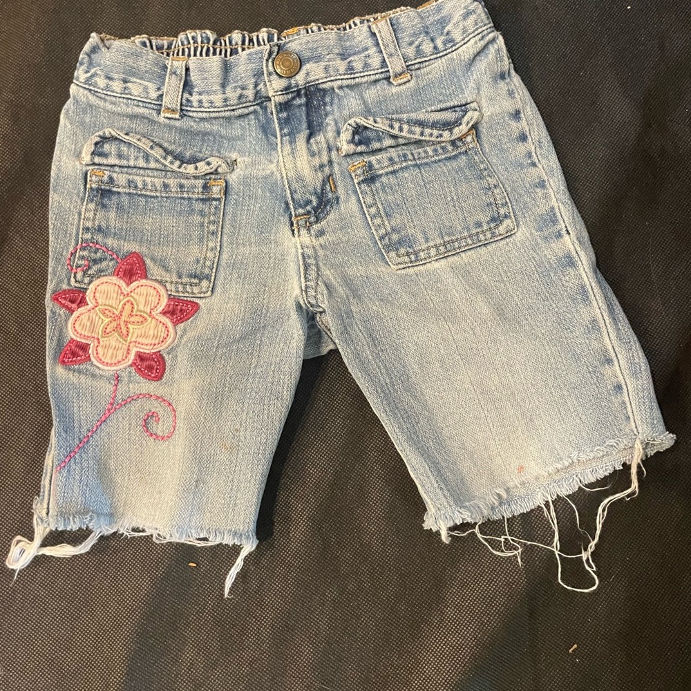 Old Navy Light Blue Denim Shorts With Flower Design on Right Thigh.